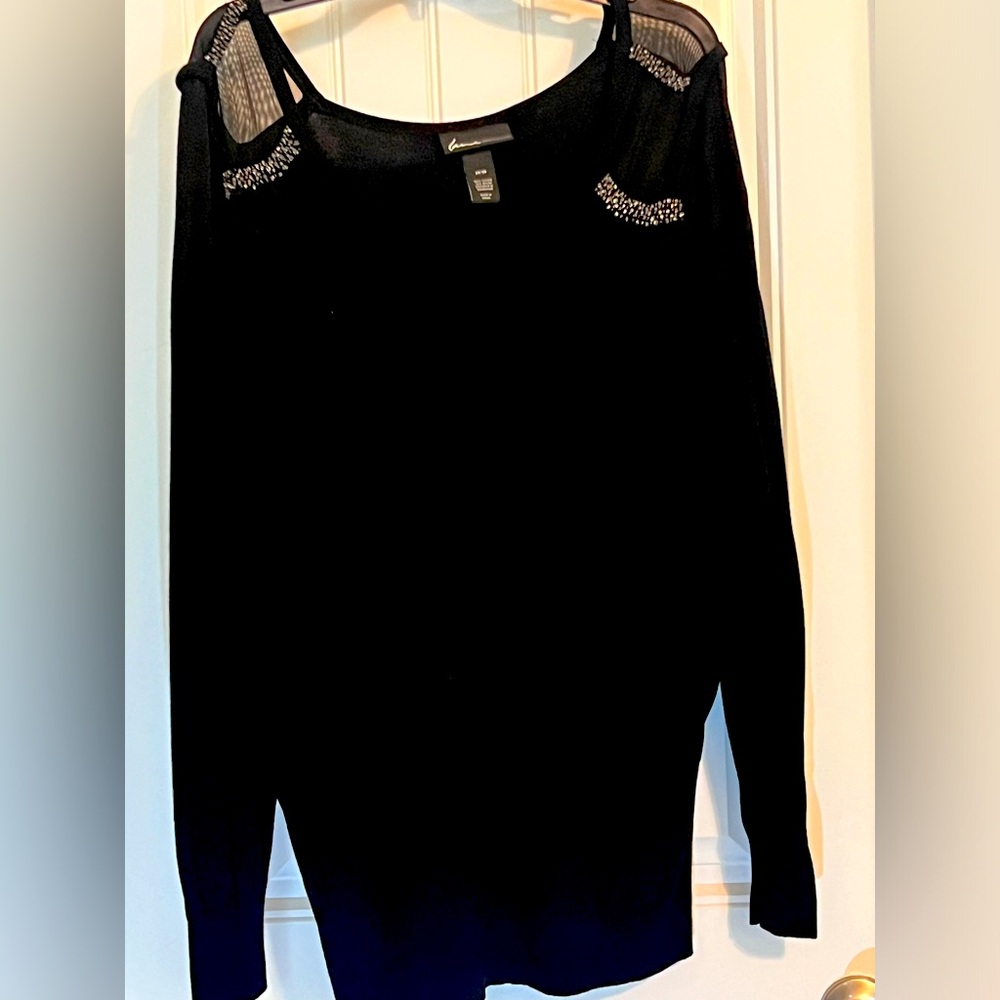 Black sweater with sheer shoulder and beading.